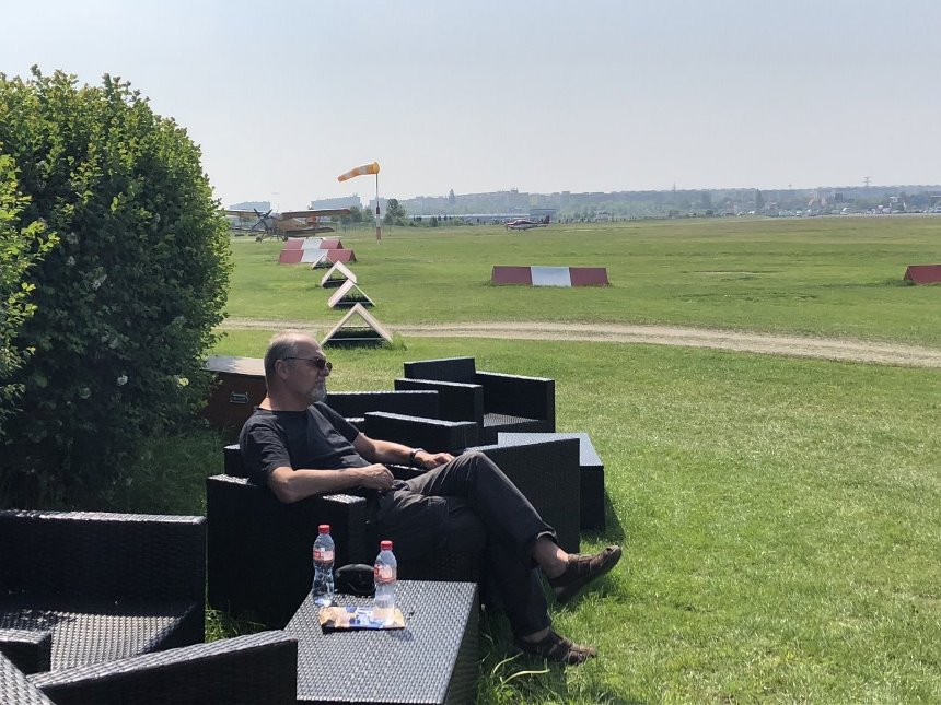 Práce pro Flying Revue je opravdu vyčerpávající - Miloš Dermišek ve venkovním posezení pro piloty na letišti v Letňanech napjatě očekává přílet Zeppelinu NT.