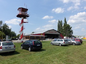 Řídící věž letiště Tábor, vpravo hangár aeroklubu. 